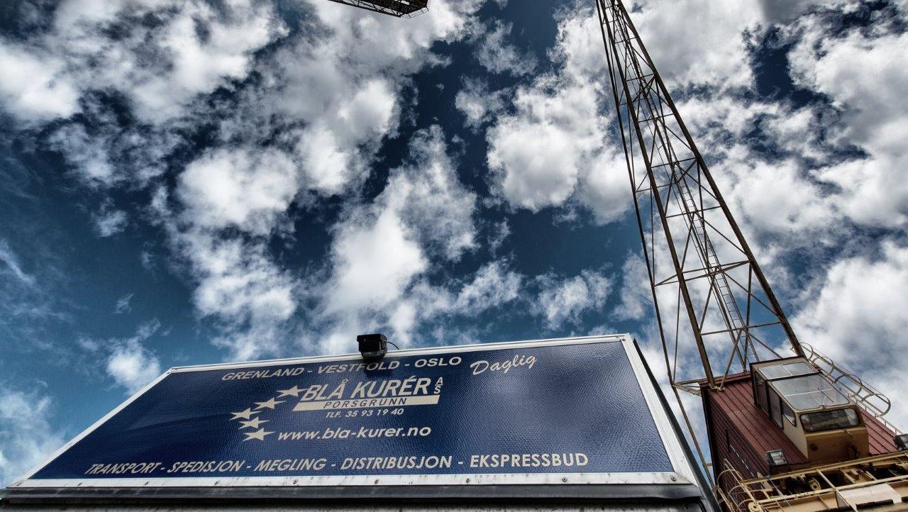 Container og kran med blå himmel i bakgrunn