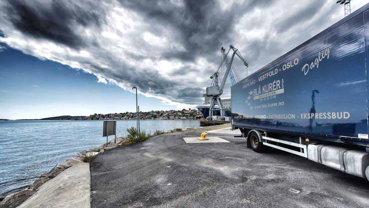 lastebil fra blå kurer parkert på en havn
